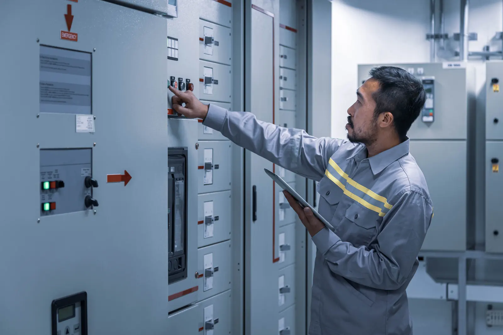 Elektriķis ar planšetdatoru pārbauda automātslēdžus sadalnes telpā